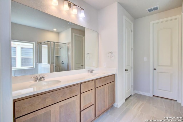 bathroom with tile patterned flooring, vanity, and a shower with door