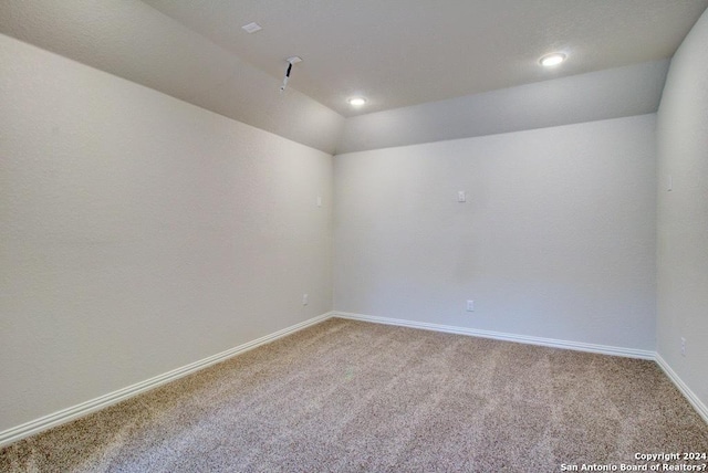 empty room featuring lofted ceiling and carpet floors