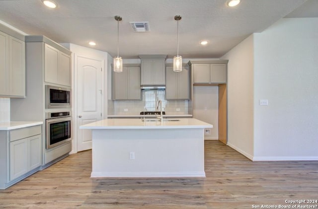 kitchen featuring light hardwood / wood-style flooring, stainless steel appliances, gray cabinets, and sink