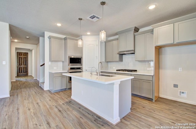 kitchen with gray cabinetry, light hardwood / wood-style floors, sink, and appliances with stainless steel finishes