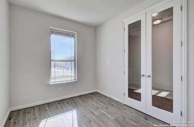 spare room featuring light hardwood / wood-style flooring and french doors