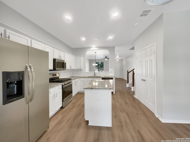 kitchen featuring a center island, white cabinetry, stainless steel appliances, and light hardwood / wood-style flooring