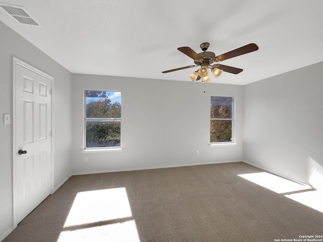 unfurnished room featuring dark colored carpet and ceiling fan