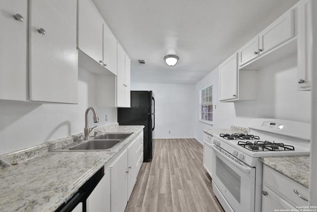 kitchen featuring light wood-type flooring, white gas range oven, white cabinetry, and sink