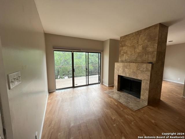 unfurnished living room with a fireplace and wood-type flooring