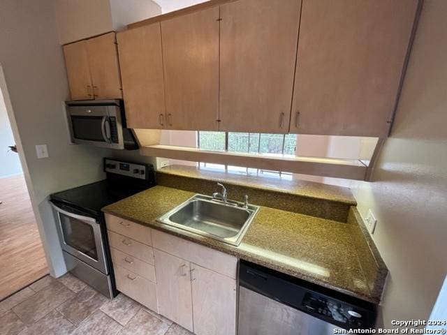 kitchen featuring light brown cabinets, sink, light wood-type flooring, and stainless steel appliances