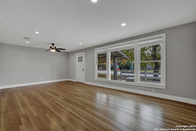 unfurnished living room featuring ceiling fan and hardwood / wood-style floors