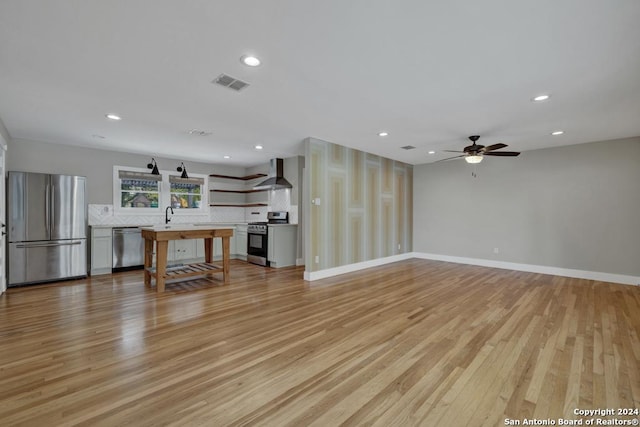 unfurnished living room with ceiling fan, light hardwood / wood-style flooring, and sink