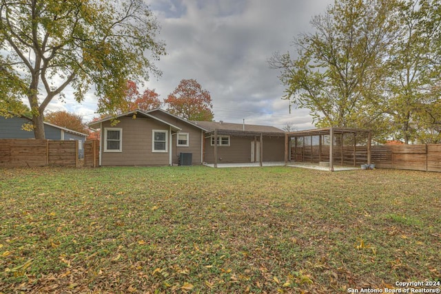 rear view of property with a yard, a patio, and cooling unit