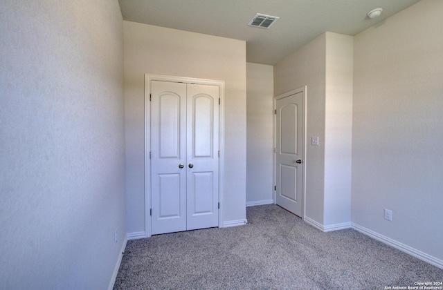 unfurnished bedroom with light carpet and a closet