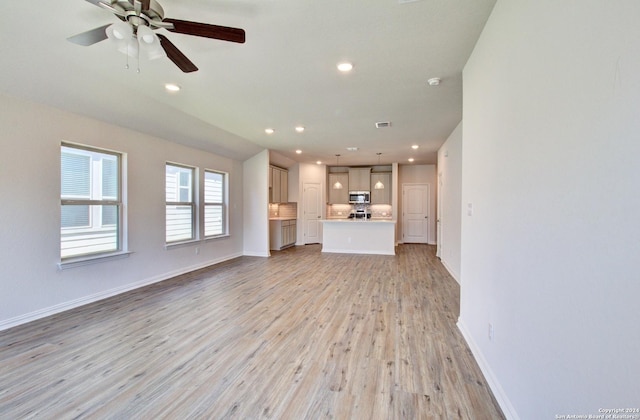 unfurnished living room with ceiling fan and light wood-type flooring