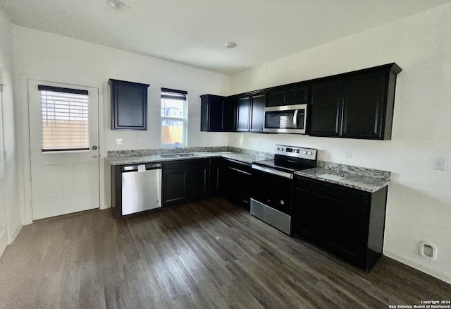 kitchen featuring dark hardwood / wood-style floors, a healthy amount of sunlight, sink, and stainless steel appliances