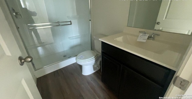 bathroom featuring vanity, hardwood / wood-style flooring, toilet, and an enclosed shower