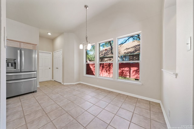 unfurnished dining area featuring a chandelier, plenty of natural light, and light tile patterned flooring