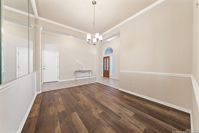 unfurnished dining area featuring hardwood / wood-style floors, a notable chandelier, and crown molding