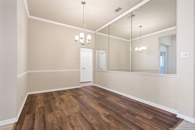 unfurnished dining area featuring dark hardwood / wood-style floors, an inviting chandelier, and crown molding