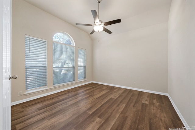 spare room featuring ceiling fan, dark wood-type flooring, and vaulted ceiling