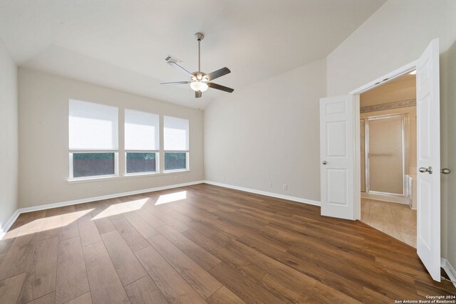 unfurnished room with dark hardwood / wood-style flooring, vaulted ceiling, and ceiling fan