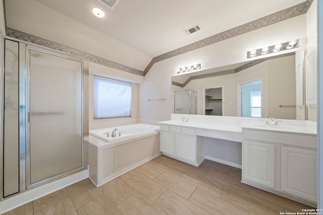 bathroom with plenty of natural light, separate shower and tub, vanity, and vaulted ceiling