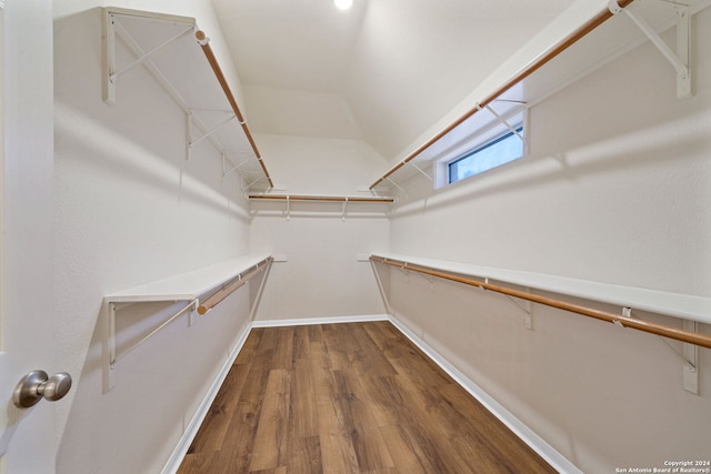 walk in closet with hardwood / wood-style flooring and lofted ceiling