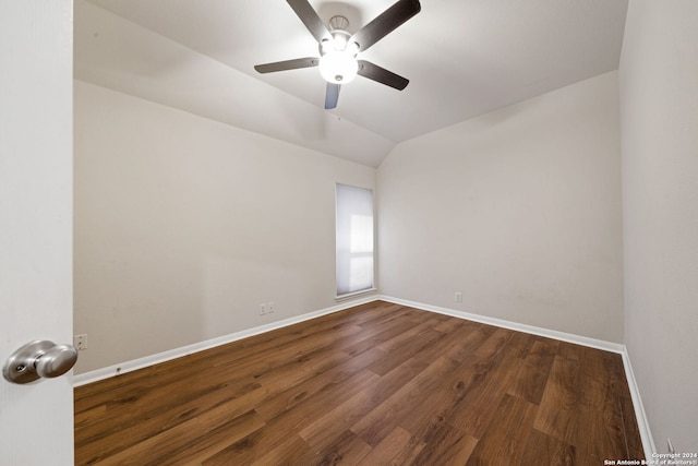 spare room with ceiling fan, dark wood-type flooring, and vaulted ceiling