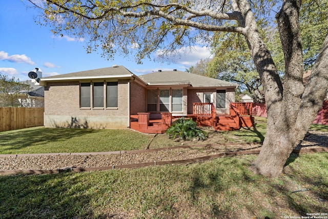 rear view of property featuring a yard and a deck