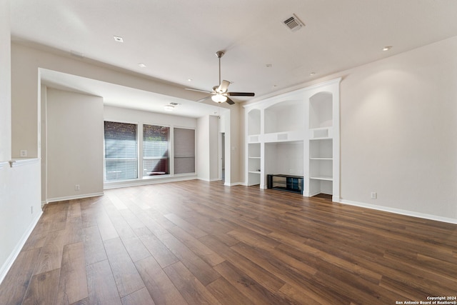 unfurnished living room featuring ceiling fan, built in features, and dark wood-type flooring