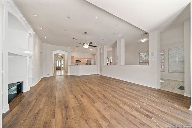 unfurnished living room with ceiling fan and light hardwood / wood-style flooring