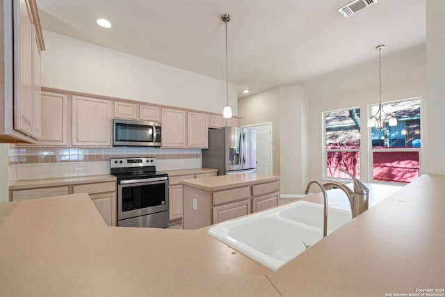 kitchen with appliances with stainless steel finishes, decorative light fixtures, light brown cabinetry, and sink