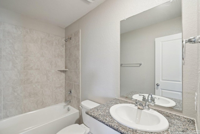 full bathroom featuring vanity, tiled shower / bath combo, and toilet