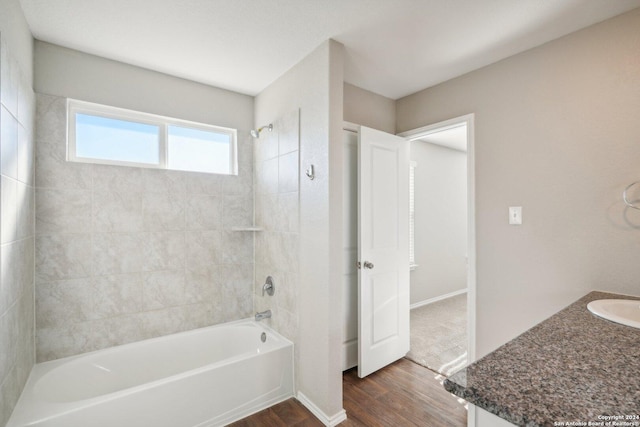 bathroom featuring hardwood / wood-style floors, vanity, and tiled shower / bath