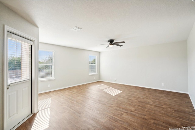 empty room featuring a textured ceiling, hardwood / wood-style flooring, and ceiling fan