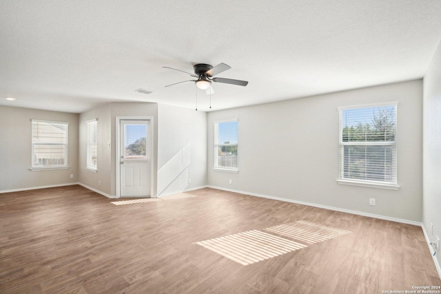 empty room featuring hardwood / wood-style flooring, plenty of natural light, and ceiling fan