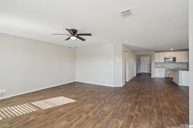 unfurnished living room featuring ceiling fan and dark wood-type flooring