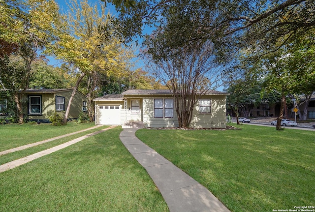 ranch-style house featuring a garage and a front lawn