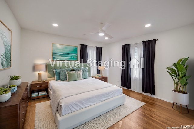 bedroom with hardwood / wood-style floors, ceiling fan, and multiple windows