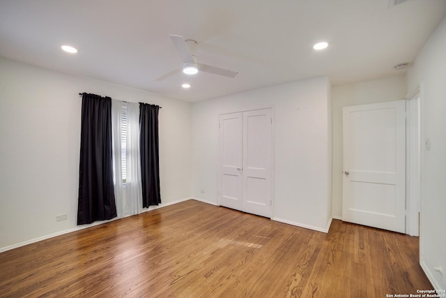 unfurnished bedroom featuring hardwood / wood-style flooring, ceiling fan, and a closet