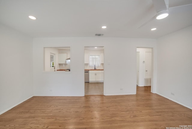 unfurnished living room with light hardwood / wood-style floors and sink