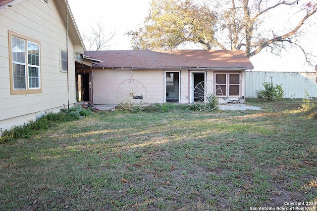 rear view of property with a yard