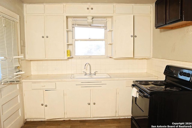 kitchen featuring electric range, dark hardwood / wood-style flooring, white cabinets, and sink