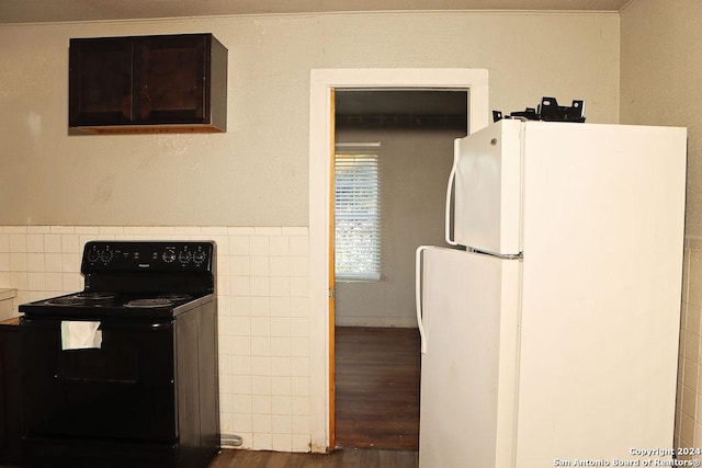 kitchen with dark wood-type flooring, white refrigerator, electric range, ornamental molding, and tile walls