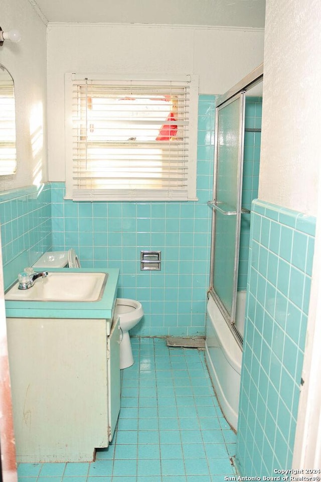 full bathroom with tile patterned floors, plenty of natural light, enclosed tub / shower combo, and vanity