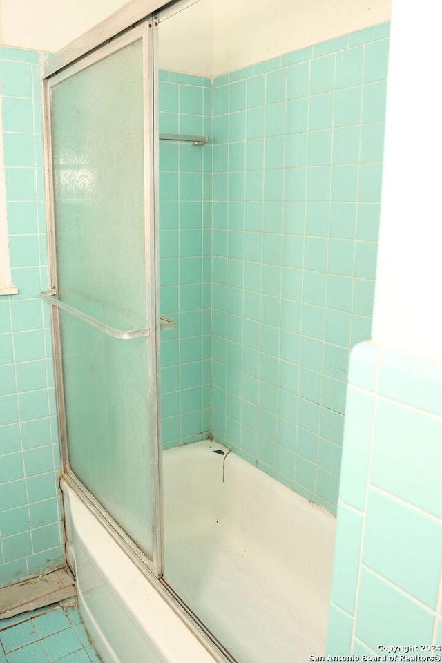 bathroom with tile patterned floors and shower / bath combination with glass door