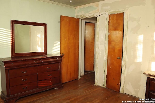 interior space with crown molding and dark wood-type flooring