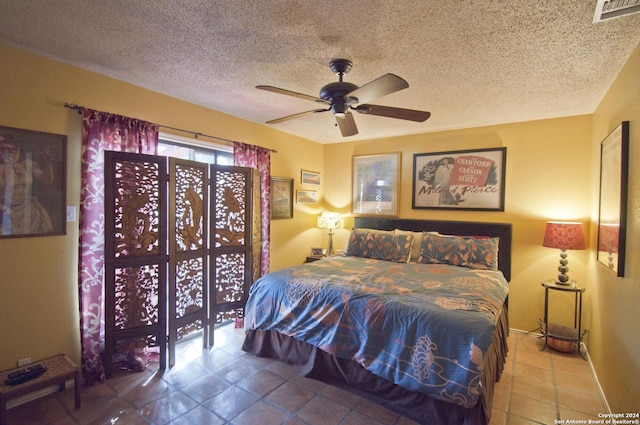 tiled bedroom with ceiling fan and a textured ceiling