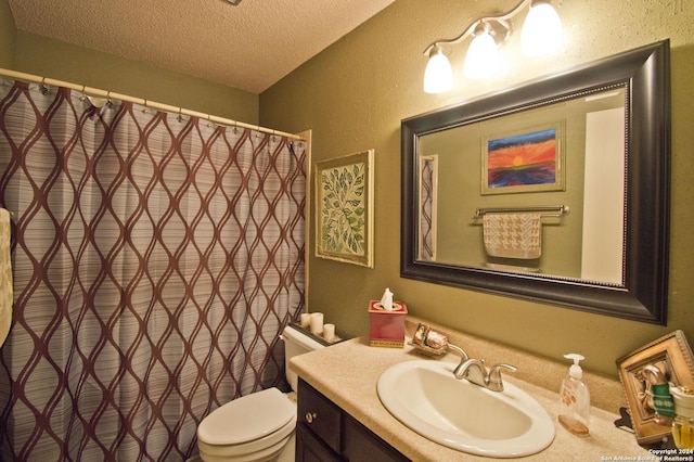 bathroom with vanity, a textured ceiling, and toilet