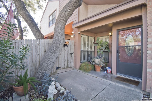 entrance to property with stucco siding and fence