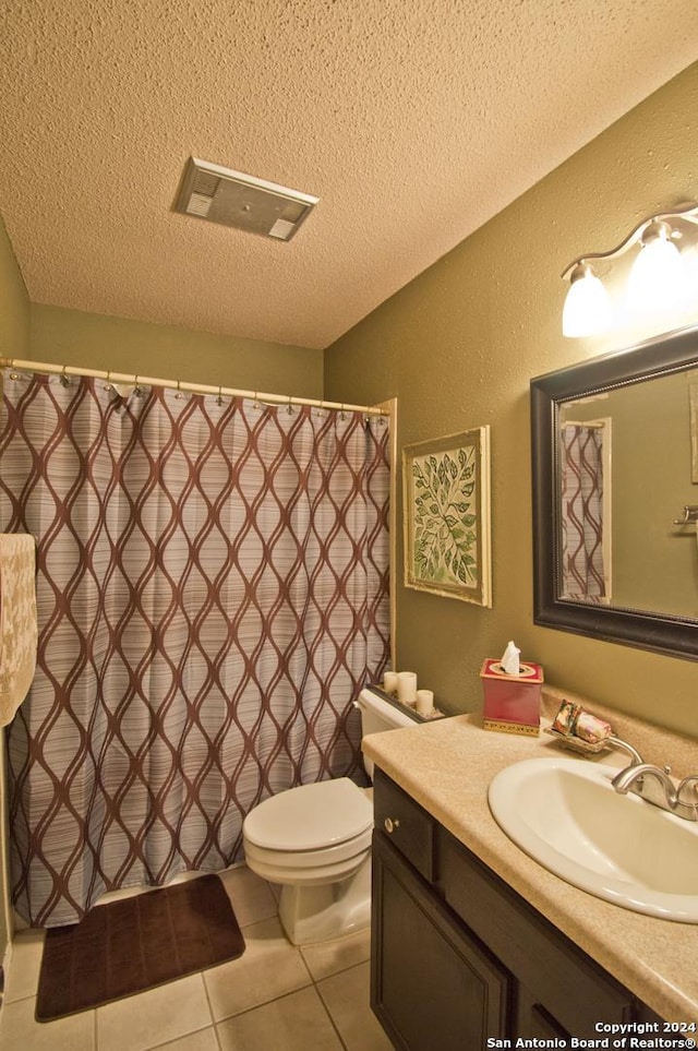 bathroom with vanity, a textured ceiling, tile patterned floors, and toilet