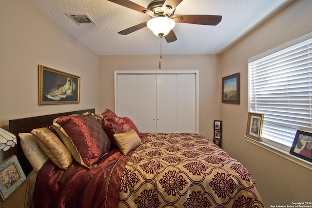 bedroom with ceiling fan, a closet, and a textured ceiling