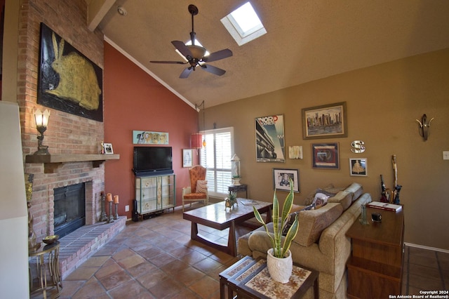 living room featuring high vaulted ceiling, a skylight, ceiling fan, a textured ceiling, and a fireplace